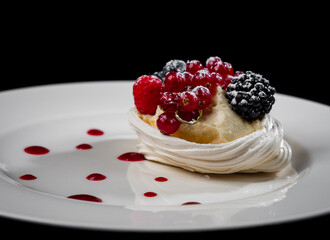 Delicious cake with berries: red currants, blueberries, blackberries. Cream and beautiful shape. Dessert in the restaurant.
