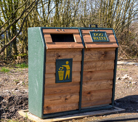Wooden bin with compartmenrs for dog waste and litte. No people.r