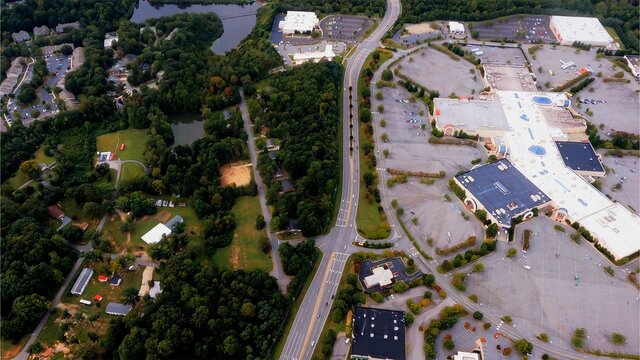 I fly over a shopping mall in High Point, NC on a Wednesday afternoon during the coronavirus COVID pandemic. Few vehicles can be seen in the parking lot showing the retail impact of the virus.