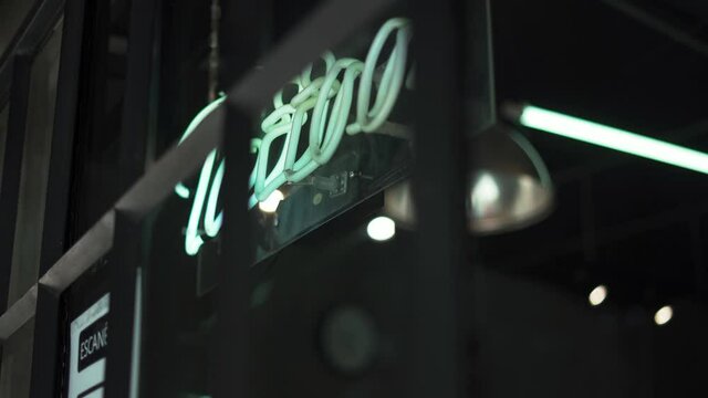 Blue Tattoo Light Sign and a QR Code that Says Scan Me on a Window