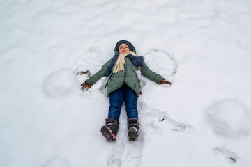 Fototapeta na wymiar little girl lying in the snow