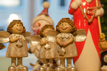 Figurines of golden angels on the shelf. New Year and Christmas holiday attributes.