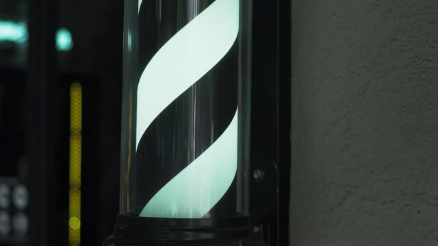 Traditional Black and White Barber Pole Light Outside a Barbershop