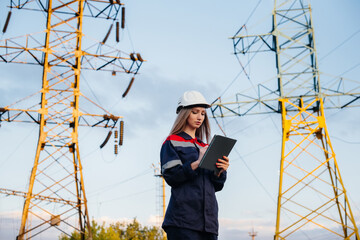 A young engineering worker inspects and controls the equipment of the power line. Energy