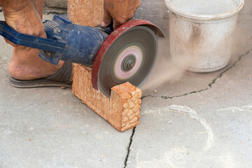 The process of sawing bricks with a grinder with a diamond disc