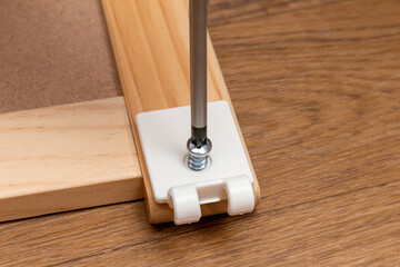 Assembling furniture with a screwdriver close-up