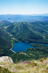 Obraz na płótnie Canvas Artificial lake in a valley between green mountains