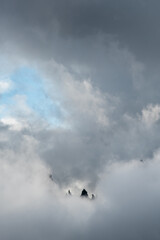 Cloudy landscape with edge of rocky mountains between the stormy sky