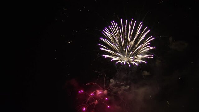 Wide aerial, purple and white firework display