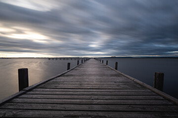 Fototapeta na wymiar pier in the sea with cloudy sky
