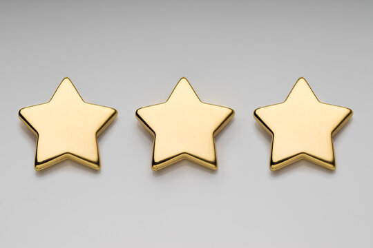 Three golden stars on light background with clipping path