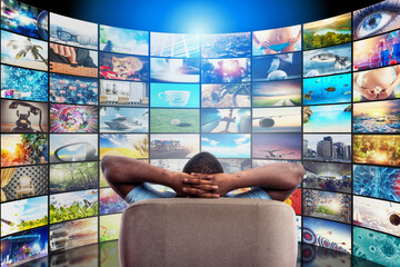 Man has fun watching a film and relaxing on a armchair. Concept of entertainment and streaming tv.