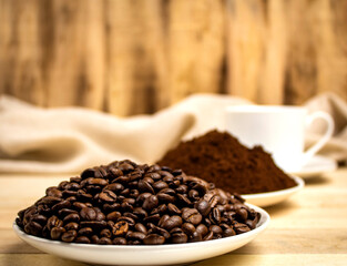 Fototapeta premium Roasted coffee grains on the background of cups with coffee