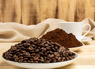 Roasted coffee grains on the background of cups with coffee