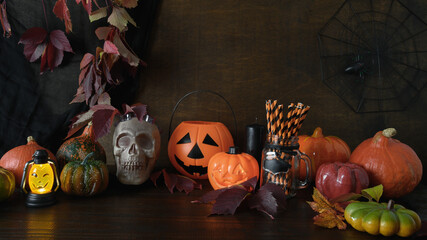 Halloween pumpkins, skull, head jack-o-lantern on dark wooden background. Preparation for fun party. Happy Halloween banner.
