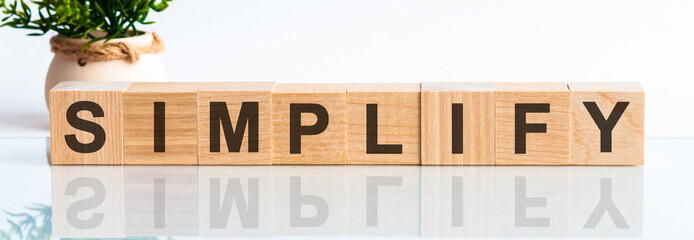 Simplify motivation text on wooden blocks business concept white background. Front view concepts, flower in the background.