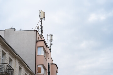 Fototapeta na wymiar Smart cellular network 5G antennas on a residential building. Large copy space.