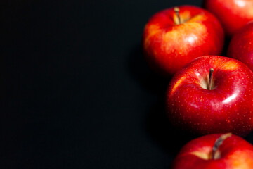 Fresh red apples on a dark background on the right side of the frame.