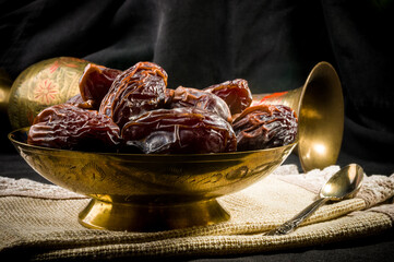 Big luxury dried date fruit in bowls on a linen napkin, kurma ramadan kareem concept, close up.