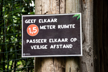 Overloon, Netherlands - October 4, 2020: Attention board (written in dutch) before store to keep social distancing. 