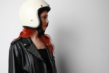 Side portrait of young woman with a motorcycle helmet posing over isolated white background. Space for text.