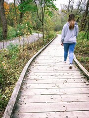 une femme marche sur un trottoir en bois dans un parc