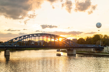 Bridge in the afternoon with a boat and a balloon at the background.