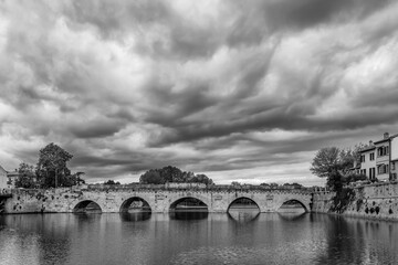 The ancient Tiberius Bridge in the historic center of Rimini, Emilia Romagna, Italy, under a...