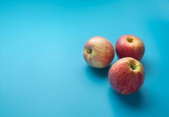Red apples on a blue background with copy space
