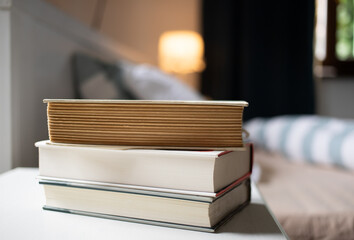 books on bedroom table by bed