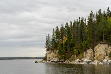 rocky cliff with trees by the water