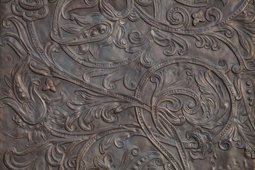 Background image - a floral pattern in the form of embossing on metal