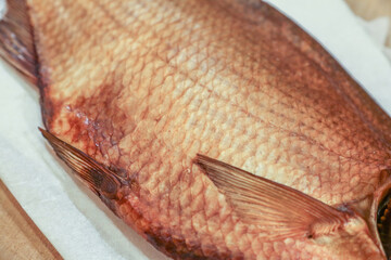 Part of a huge raw smoked fish with golden scales. Best beer snack