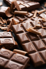 Broken chocolate bars on dark background