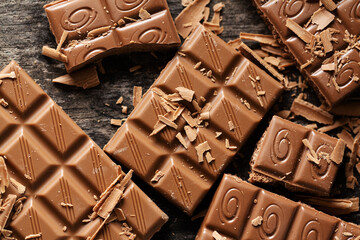 Broken chocolate bars on dark background
