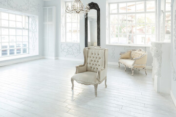 Luxury rich living room interior design with elegant classic furniture and wall decorations. Large light white room with big window