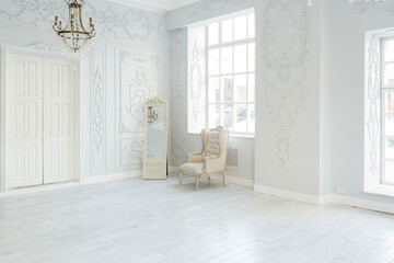 Luxury rich living room interior design with elegant classic furniture and wall decorations. Large light white room with big window
