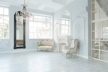 Luxury rich living room interior design with elegant classic furniture and wall decorations. Large light white room with big window