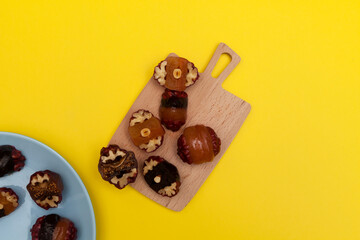 Healthy oriental sweets on a wooden cutting board. Energy bites. Candy sugar-free on a yellow background with copy space