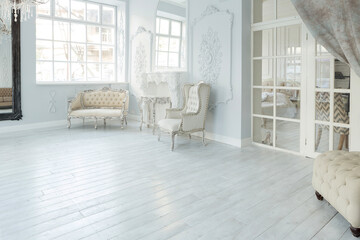 Luxury rich living room interior design with elegant classic furniture and wall decorations. Large light white room with big window