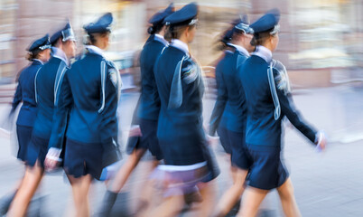 a group of girls in uniform strides across the city