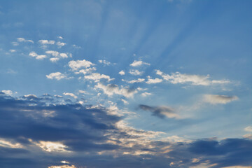 The sky at sunset. Cumulus clouds lit by the rays of the setting sun.