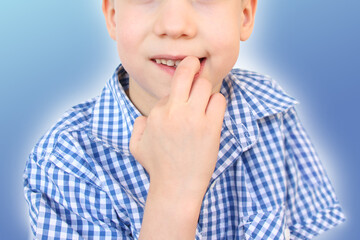 little boy, kid nibbles and bites a nail on his hand, close-up, the concept of psychological disorder, stress, bad childhood habits