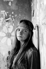 Portrait of young cute girl hippie, dirty background. Black and white photo.