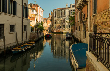 Fototapeta na wymiar Venice canal with boats and blue sky in sunshine
