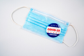 Face mask with american flag colored button with the text covid-19 vaccine..Voting, covid-19 and presidential election concept 2020.