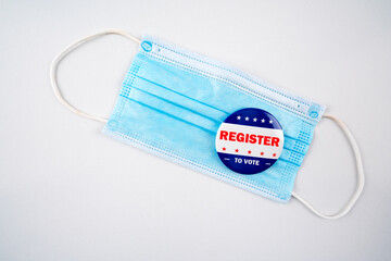 Face mask with american flag colored button with the text register to vote..Voting, covid-19 and presidential election concept 2020.