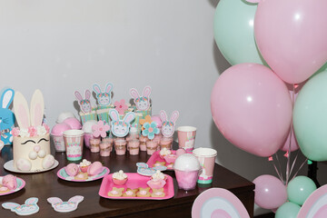 Thematic decoration for parties; Baby Shower - Table decorated with: Cakes, sweets, paper rabbits, and balloons.