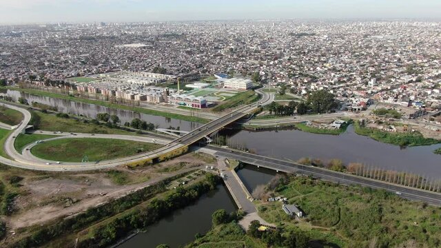 Video desde un dron de un puente que cruza un peque&ntilde;o r&iacute;o, dentro de una gran ciudad.