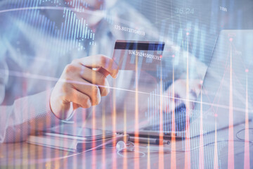 Fototapeta na wymiar Double exposure of man hands holding a credit card and Forex graph drawing. Stock trading and digital fintech in Internet E-commerce concept.